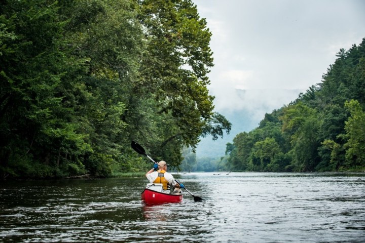 a man riding on the back of a boat in a body of water